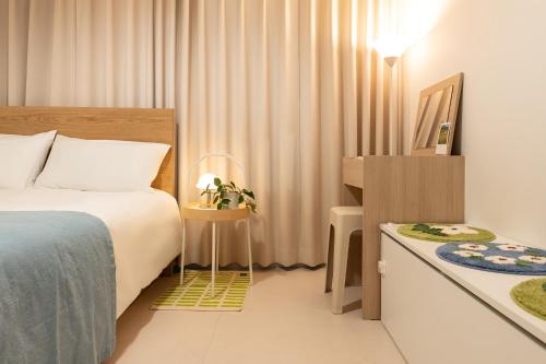 a bedroom with a bed and a table with a television at Danchu stay in Seoul