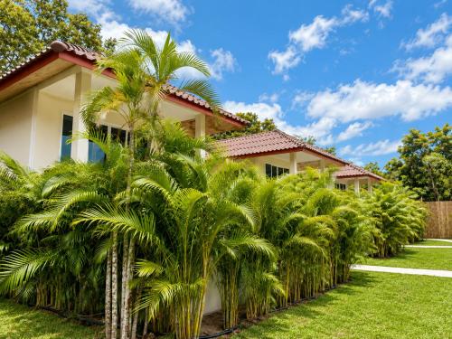 a house with palm trees in front of it at Oh'lala Pool Cottages in Ban Tai
