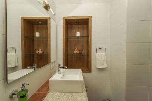 a white bathroom with a sink and a mirror at Azure Luxury 3-Bedroom Penthouse Candolim, Next to Novotel and Starbucks, close to Beach - By Lembranca in Candolim