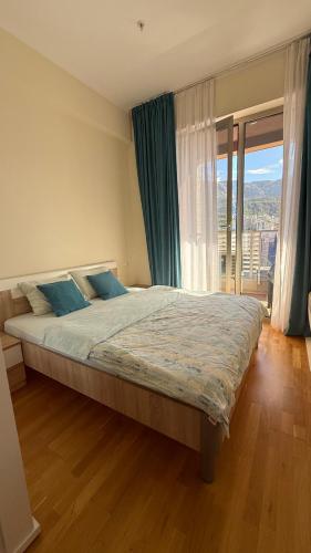 a bedroom with a large bed and a large window at Harmonia Apart Hotel in Boreti