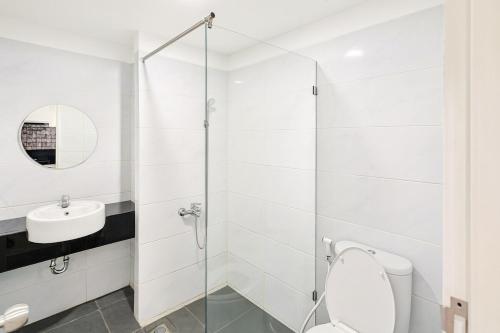 a white bathroom with a toilet and a sink at Altuz Apartment Seturan Yogyakarta in Seturan