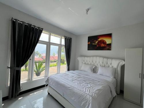 a bedroom with a bed and a large window at new pratama in Sampal 2