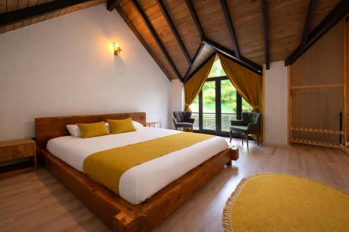 a bedroom with a large bed and a large window at Villa Vrosi - فلل وأكواخ فيروز السياحية in Ardeşen