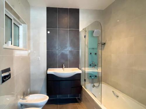 a bathroom with a sink and a shower at AuraHouse Algarve in Lagoa