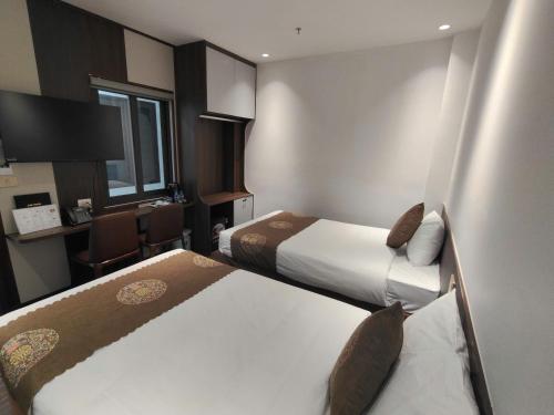 ein Hotelzimmer mit zwei Betten und einem Schreibtisch in der Unterkunft CMC Hotel in Bắc Giang