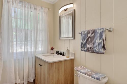a bathroom with a toilet and a sink and a window at Covea Cabin in Luray
