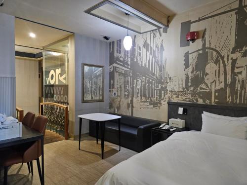 a bedroom with a bed and a desk and a table at Vov Hotel in Busan