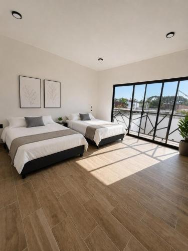 a bedroom with two beds and a large window at Casa Luna con alberca privada y billar in Cuautla Morelos