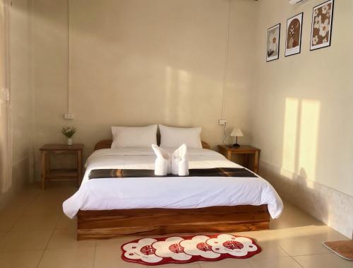 a bedroom with a bed with two white shoes on it at XAIYASITH guesthouse in Nongkhiaw