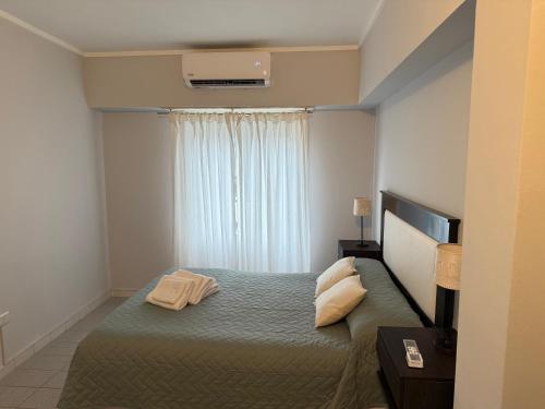 a bedroom with a bed with two pillows and a window at Dpto del Cerro in Tandil