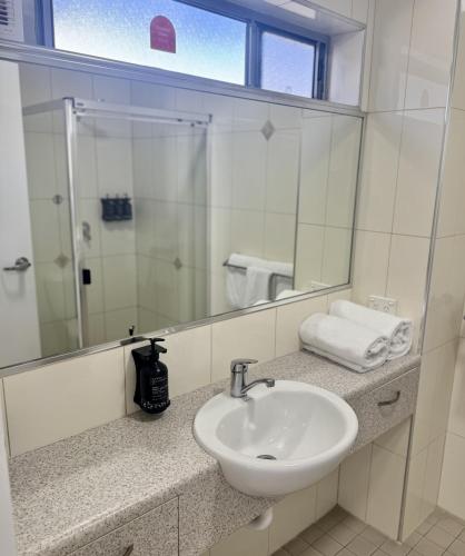 a bathroom with a sink and a mirror at Nambour Heights Motel in Nambour