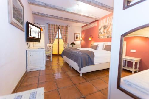 a bedroom with a bed and a mirror at 4-Sterne Erlebnishotel El Andaluz, Europa-Park Erlebnis-Resort in Rust