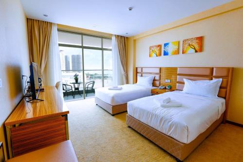 a hotel room with two beds and a television at Diamond Pearl Hotel ,Phnom Penh,Royel Palace, Mekong RIver,Swimming Pool in Phnom Penh