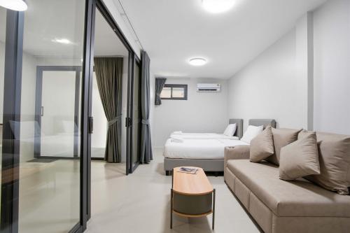 a living room with a couch and a bed at Tiva Residence Bangkok in Bangkok