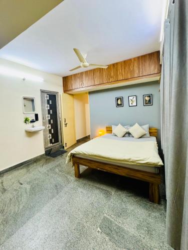 a bedroom with a bed and a ceiling at Namma Suites 1BHK Serviced Apartment near NIMHANS & St Johns hospital in Bangalore