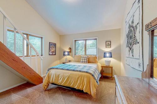 a bedroom with a bed and a staircase with windows at Juniper Haven Retreat in Sun Valley