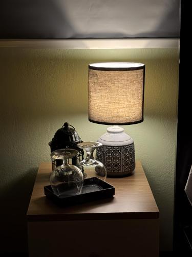 a table with a lamp on top of a night stand at Chic Homestay Narathiwat in Ban Kam Pong Ba Ru