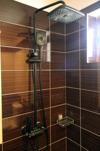 a shower with a shower head in a bathroom at Hotel Villa Kapo Pool & Bar in Ksamil