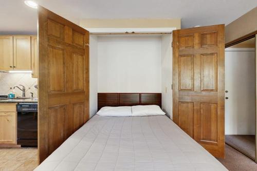 a bedroom with a large bed with a wooden door at On the Rapids - B Unit in Grand Lake