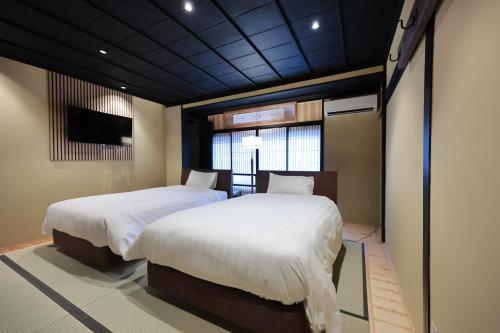 a bedroom with two beds and a window at 御宿 凪ぐ Takayama in Takayama