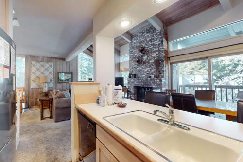 a kitchen with a sink and a living room at Chamonix 100 in Mammoth Lakes