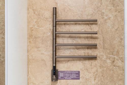 a set of three stainless steel towel bars on a wall at Nostalgia S Hotel Beijing Guomao in Beijing