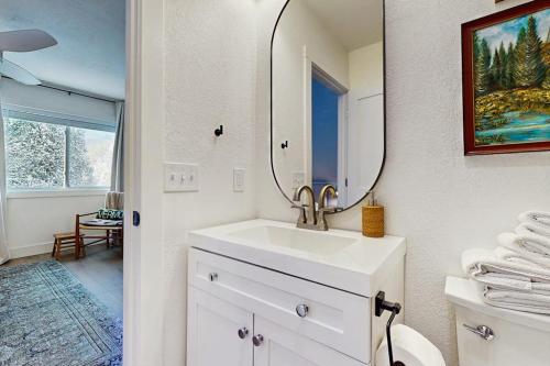 a white bathroom with a sink and a mirror at Mill Brook Retreat - Unit 2 in Waitsfield