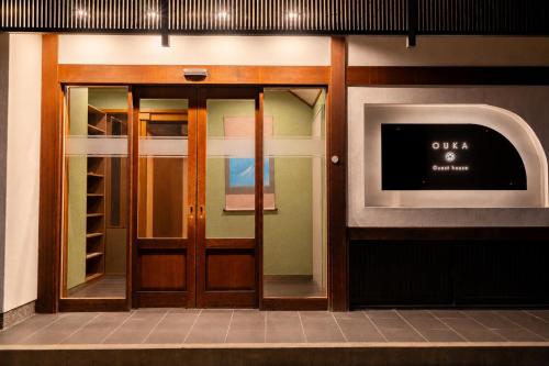 an entrance to a building with a door and a tv at Guest House Ouka in Takayama