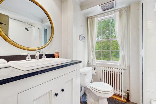 a bathroom with a sink and a toilet and a mirror at Kingdom Valley Farmhouse in Chester