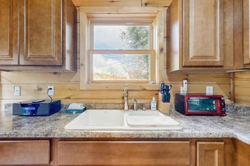 a kitchen counter with a sink and a window at Brook Haven Cabin in Jeffersonville