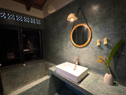 a bathroom with a sink and a mirror at Half Village, Nha Trang in Nha Trang