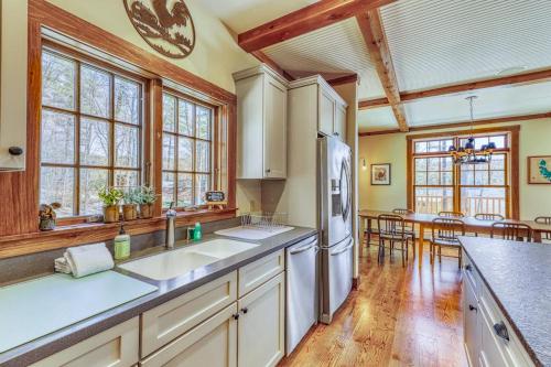 a kitchen with white appliances and wooden floors and windows at Lake Rescue Retreat in Ludlow