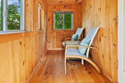 two chairs and a table in a room with wooden walls at Davis Outpost Pet-Friendly Quiet Cabin w AC Screened Sunroom Walk to Trails in Otter Creek