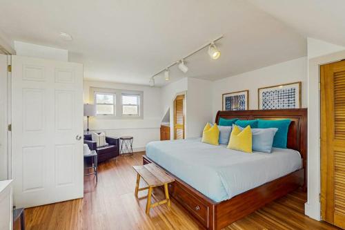 a bedroom with a large bed with blue and yellow pillows at Stowe Mountain Road Getaway in Stowe