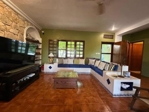 a living room with a couch and a piano at Los Dias Enmedio in Telchac Puerto