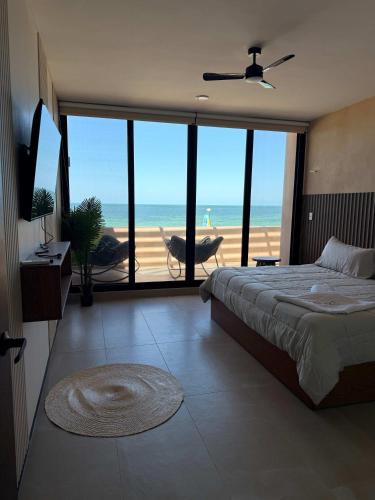a bedroom with a bed and a view of the beach at Villa con rooftop para atardeceres in Telchac Puerto