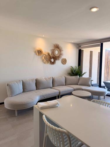 a living room with a couch and a table at Villa oasis among the palms in Telchac Puerto