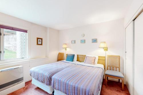 a white bedroom with a bed and a tv at Vermont Paradise in Warren