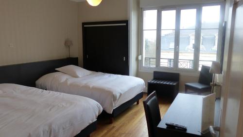 a hotel room with two beds and a window at Hotel De L'Europe in Toul