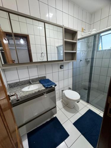 a bathroom with a sink and a toilet and a mirror at Sobrado Azul in Várzea Grande