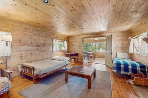 a log cabin bedroom with a bed and a table at Garden Island's Pine in Charlotte