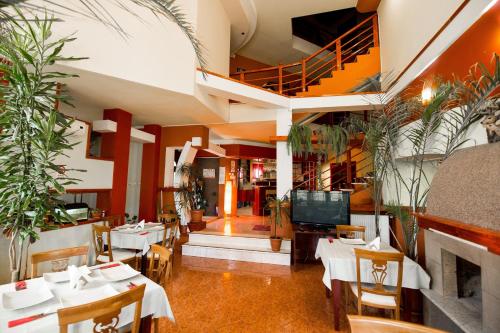 a restaurant with tables and chairs and a staircase at Pensiunea Crystal in Iaşi