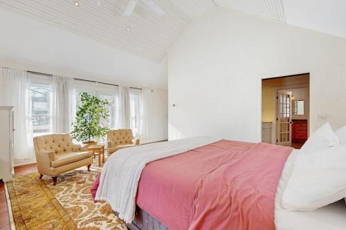 a white bedroom with a large bed and a chair at High Street Retreat in Cavendish
