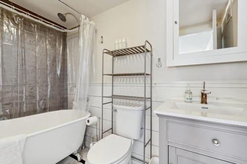 a white bathroom with a toilet and a sink at High Street Retreat in Cavendish