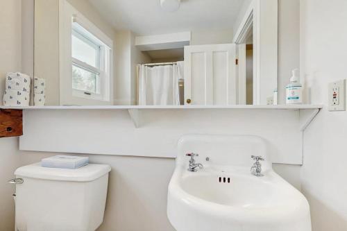 a white bathroom with a toilet and a sink at Stowe Mountain Road Retreat in Stowe