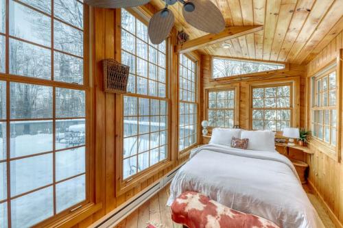 a bedroom with a bed in a room with windows at Mount Snow Chalet in West Dover
