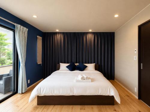 a bedroom with a large bed with blue walls at Rayful Hayama in Hayama