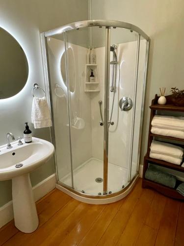 a bathroom with a shower and a sink at Wisteria Villa in Russell