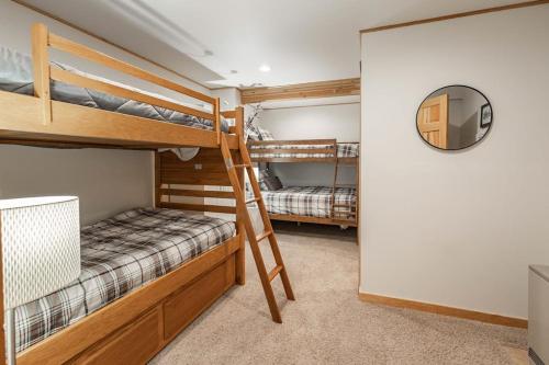 two bunk beds in a room with a mirror at Mountain Calling in Grand Lake
