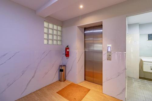 a elevator lobby with a marble wall at RedDoorz Plus at Suba Hotel Tanjung Duren in Jakarta